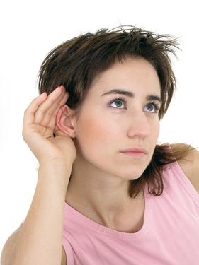 woman with hand to ear listening